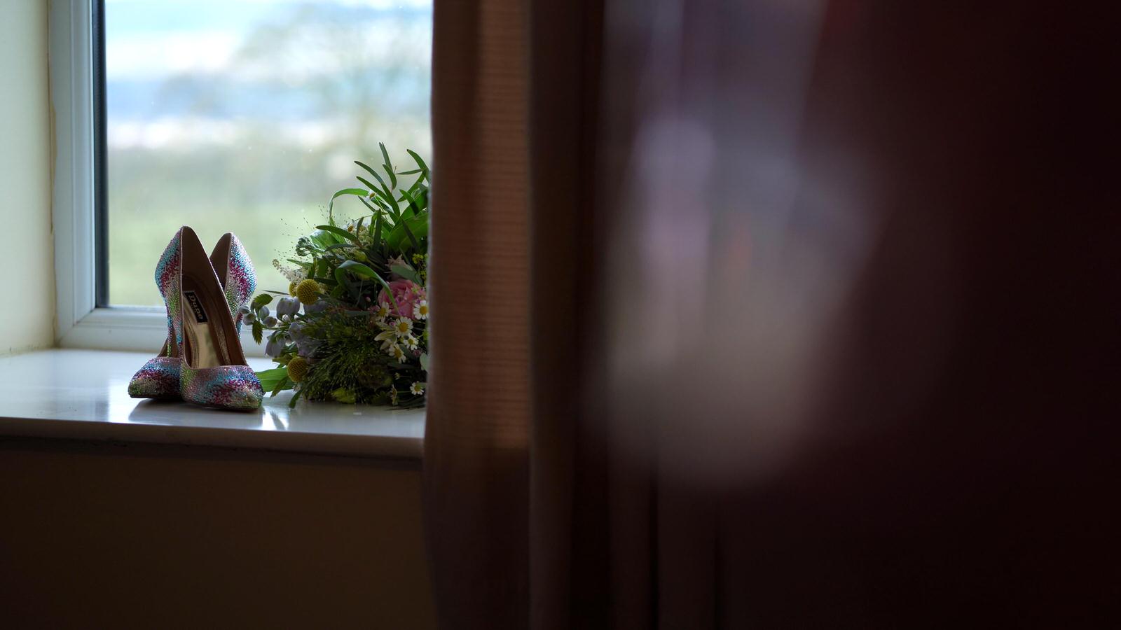 rainbow wedding shoes and bouquet in window