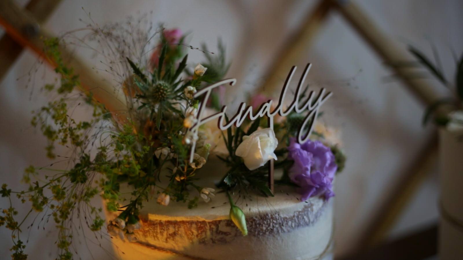 finally cake topper on rustic wedding cake