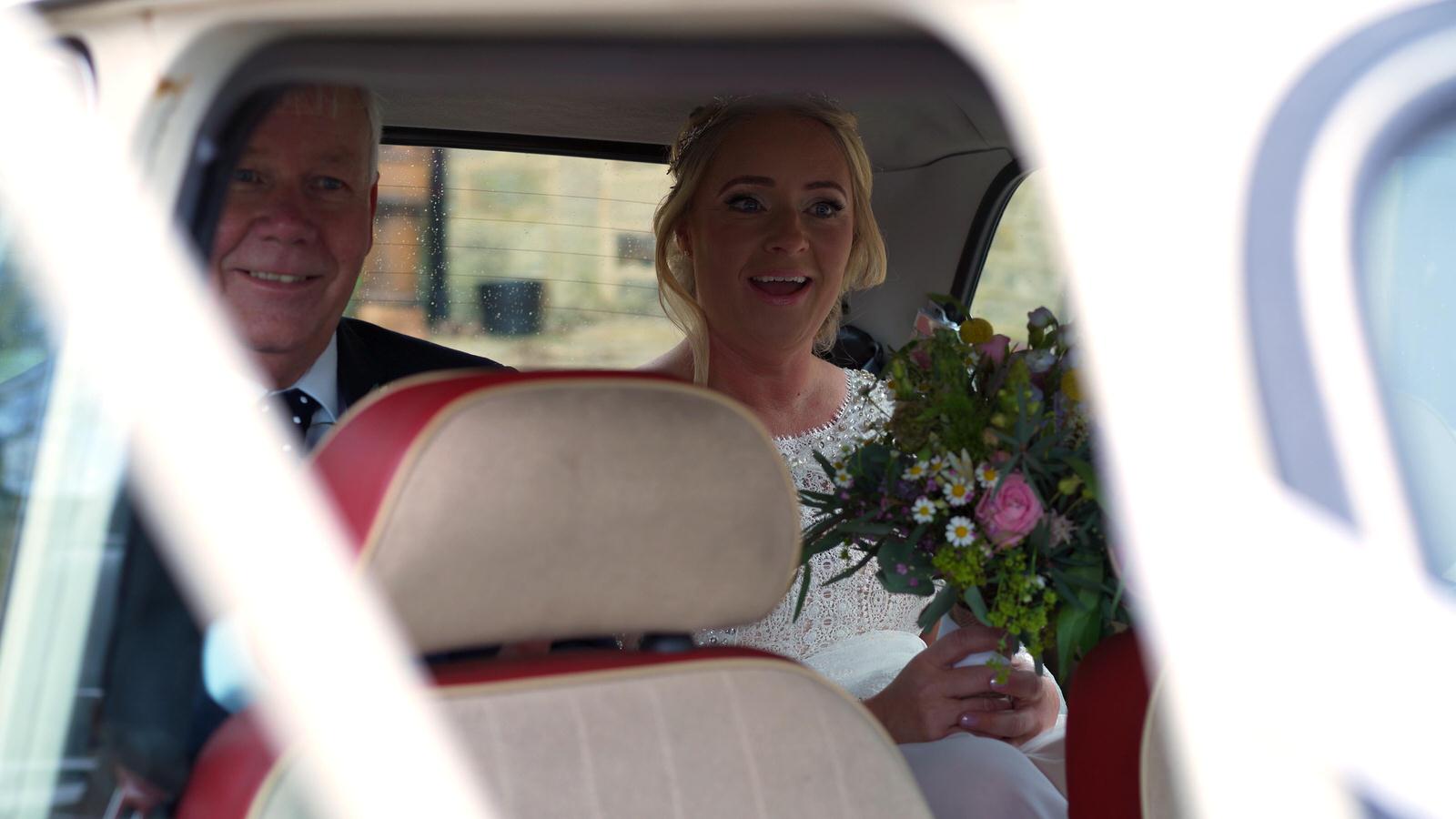 dad and bride sit in classic mini before ceremony