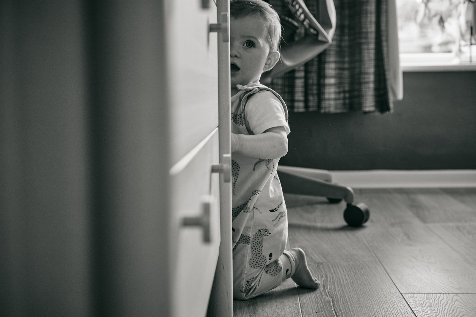 toddler peeks at photographer during shoot in Manchester