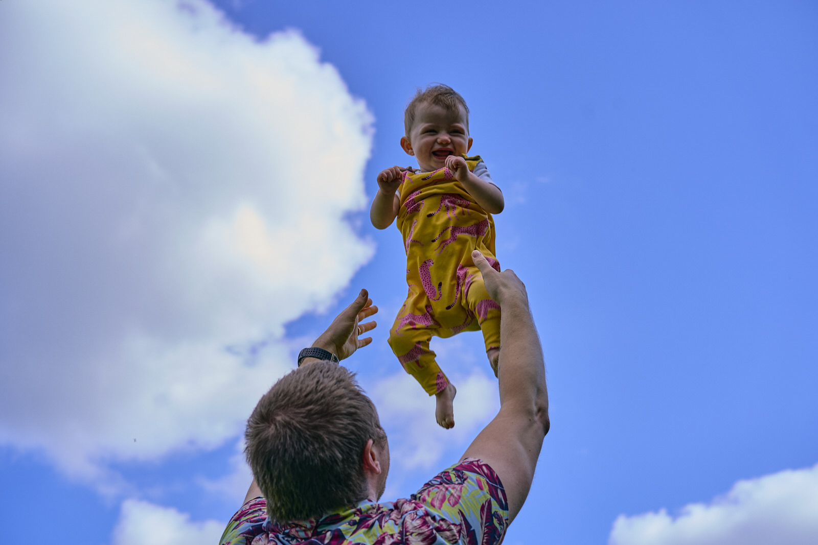 dad throws baby in to the air and they laugh