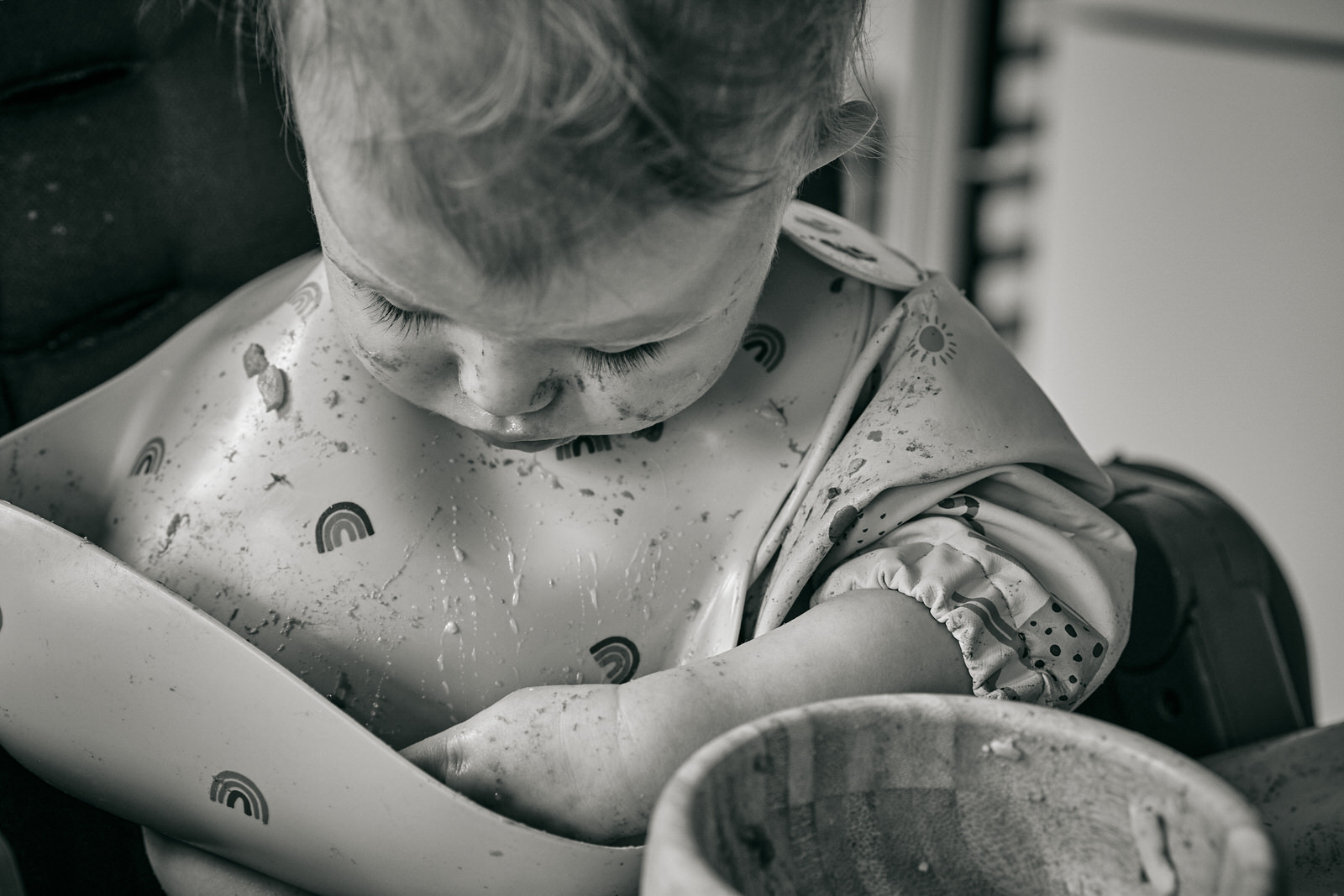 baby digs food out of bib