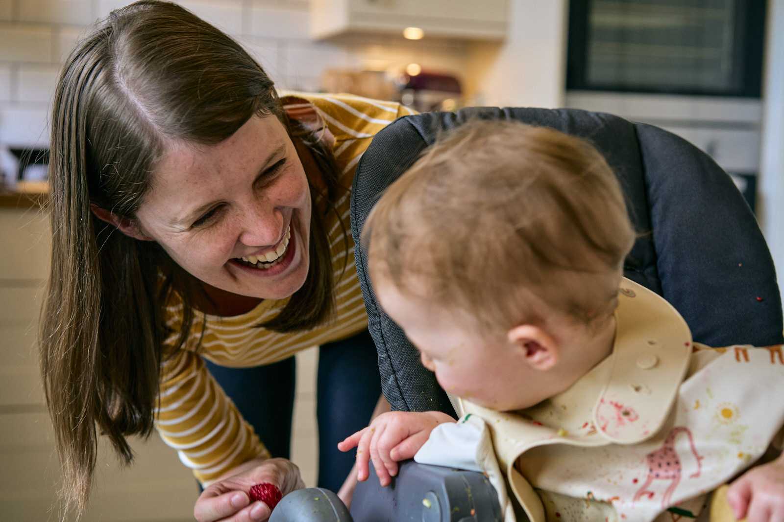 mum laughs with baby during home photography shoot