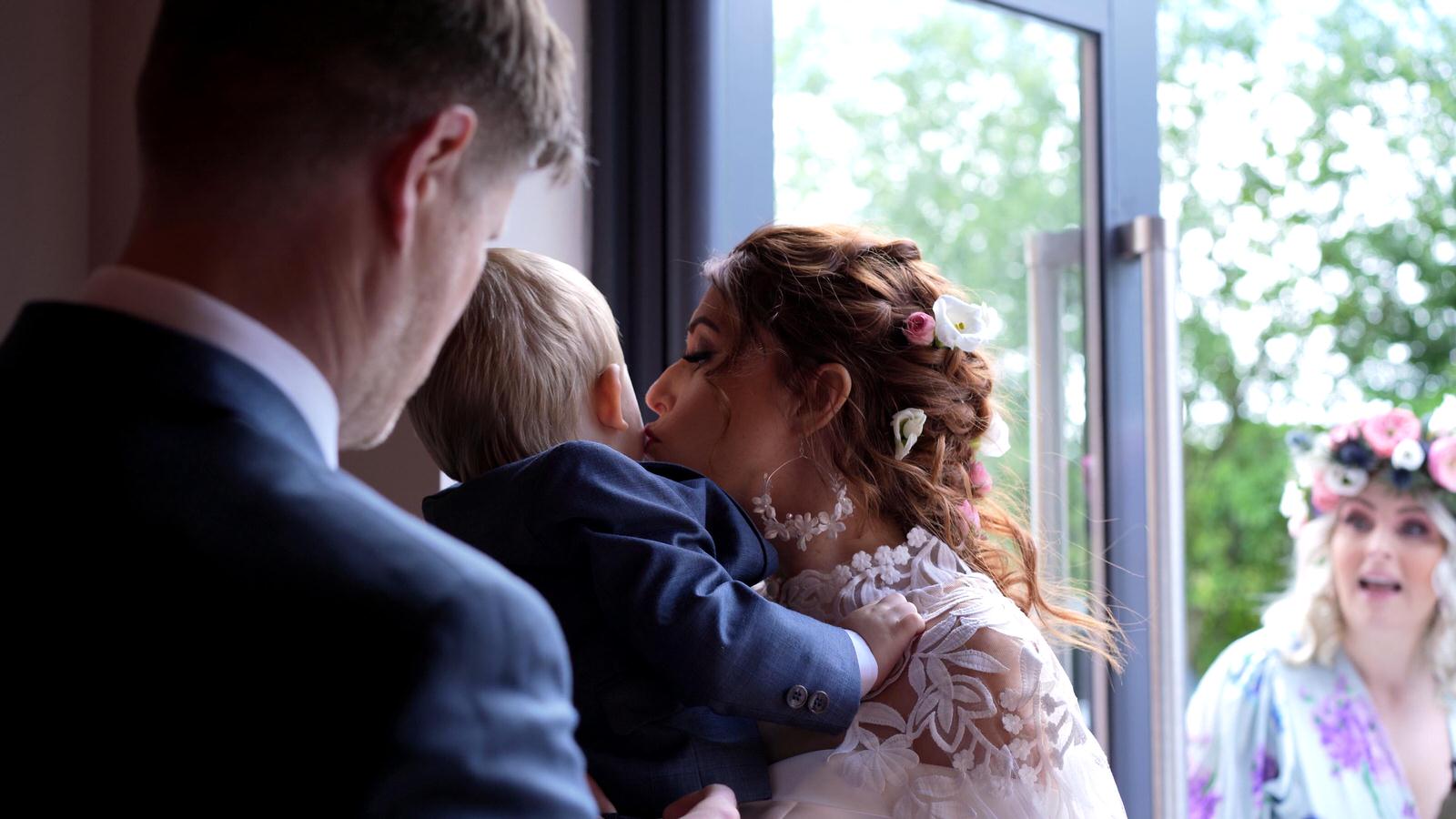 the bride kisses her son at midge hall church
