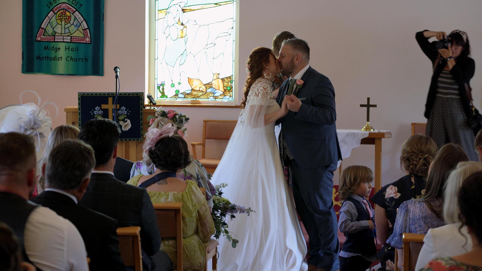 a video still of the couple kissing at midge hall church Leyland