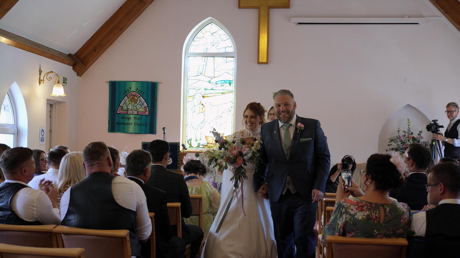 newlyweds walk down the aisle at Midge Hall Church Leyland