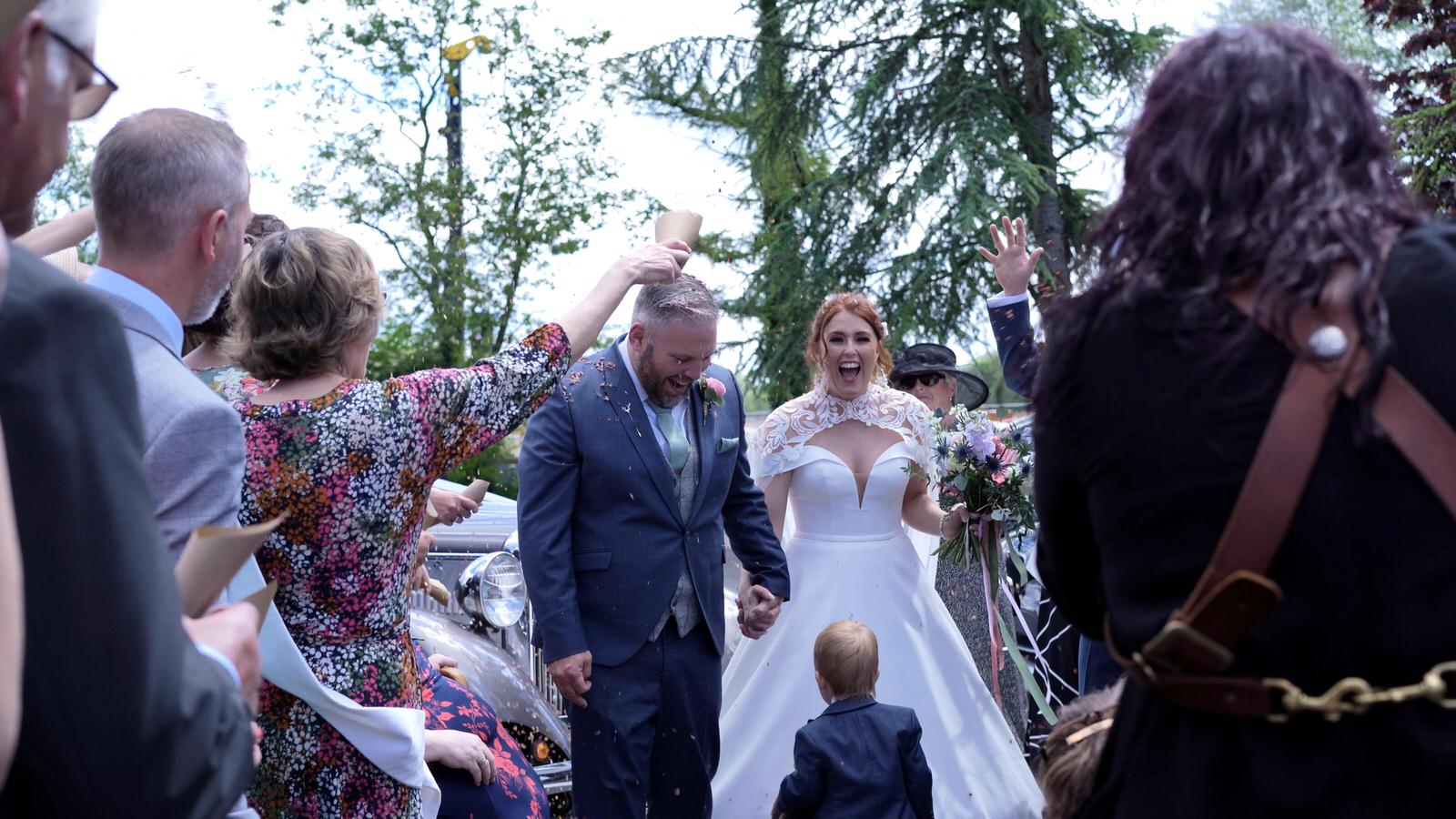 a couple laugh during confetti video outside church