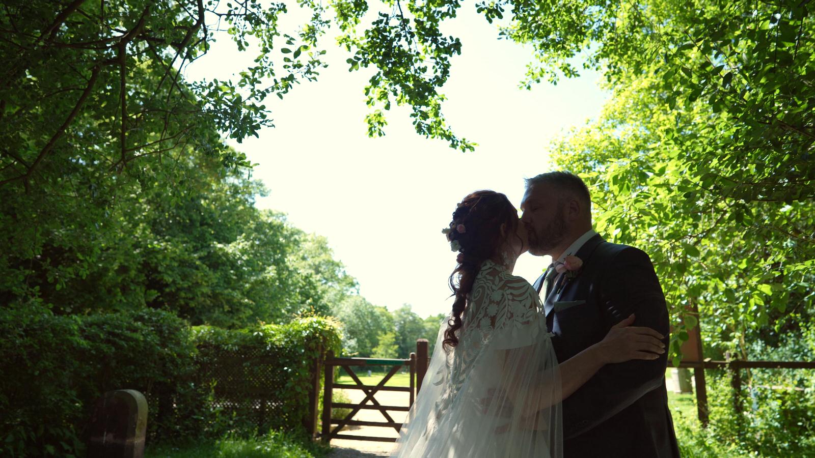 a couple kiss under trees in Mawdesley
