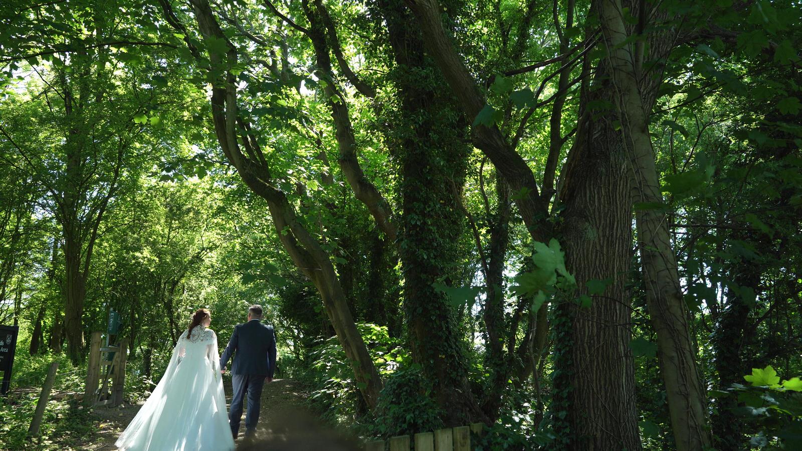 a bride and groom walk through Mawdesley green for video