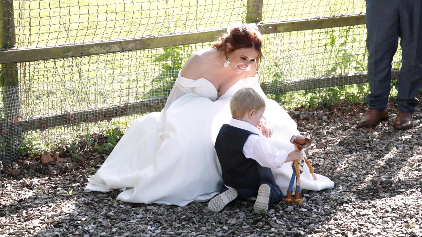 a candid video still of bride playing with son