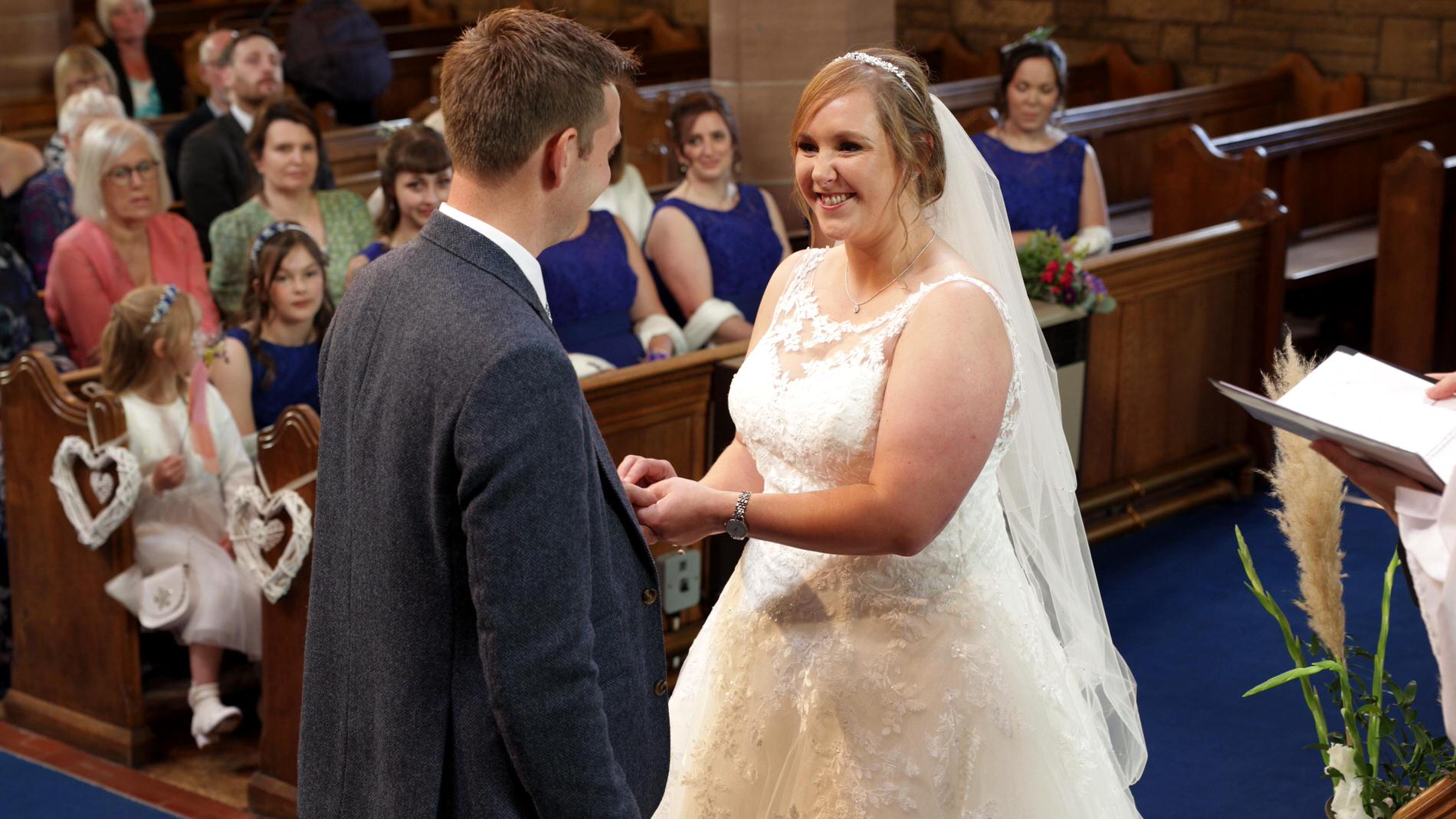couple exchange wedding rings at St Lukes Orrell