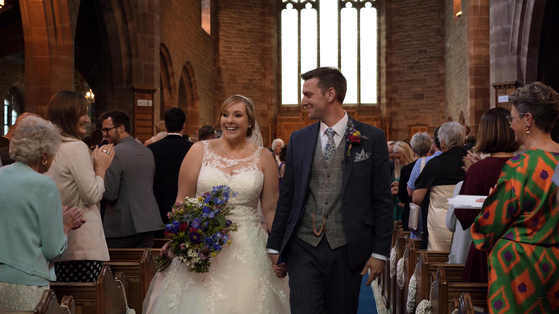 happy couple walk back down aisle at St Lukes Orrell