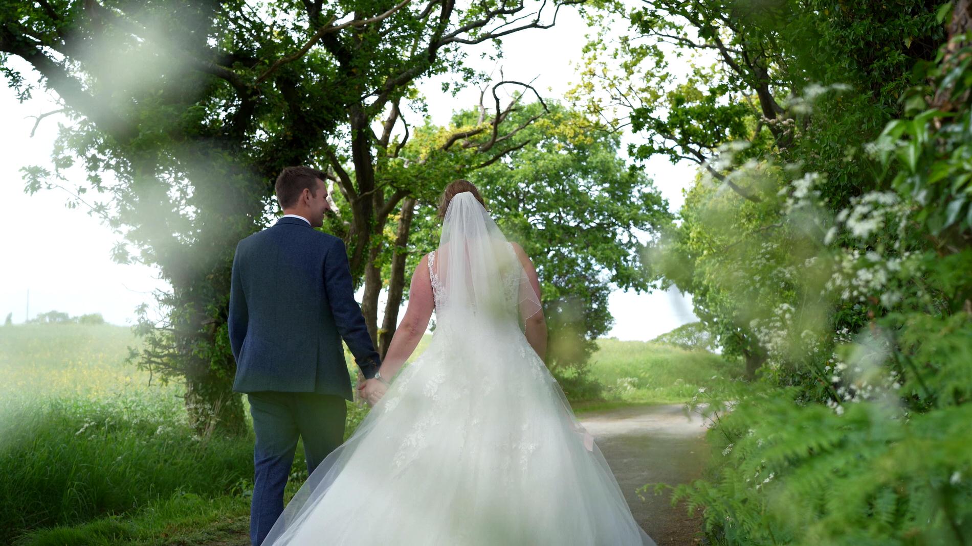 bride and groom walk down country lane in Lancashire