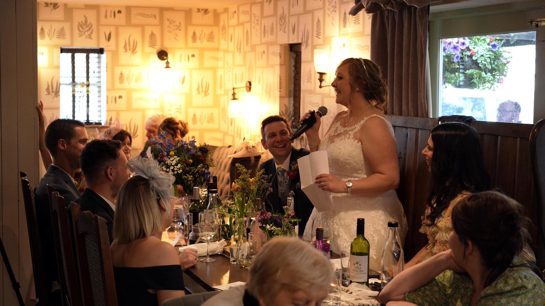 bride stands to do a wedding speech
