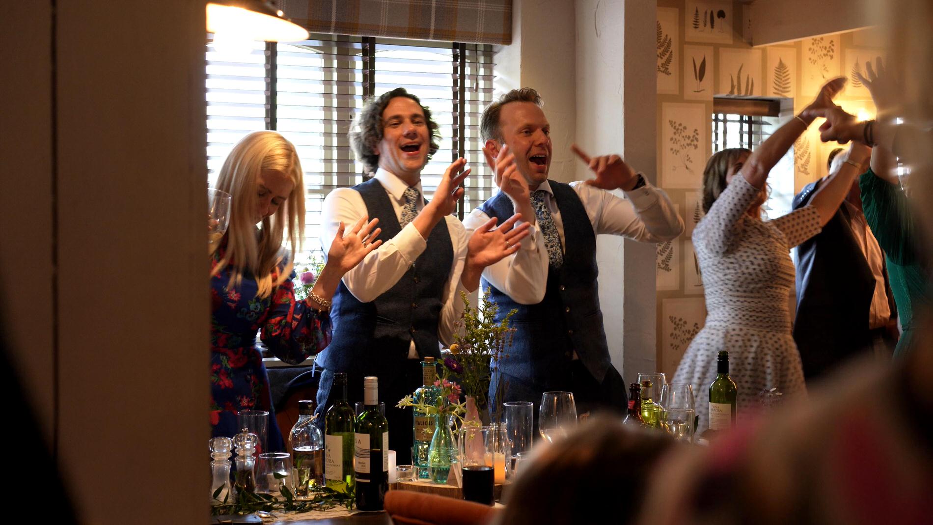 guests dance at their tables during wedding reception