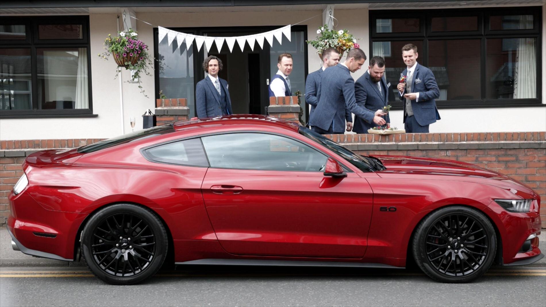 red mustang GT wedding car parks up outside grooms house