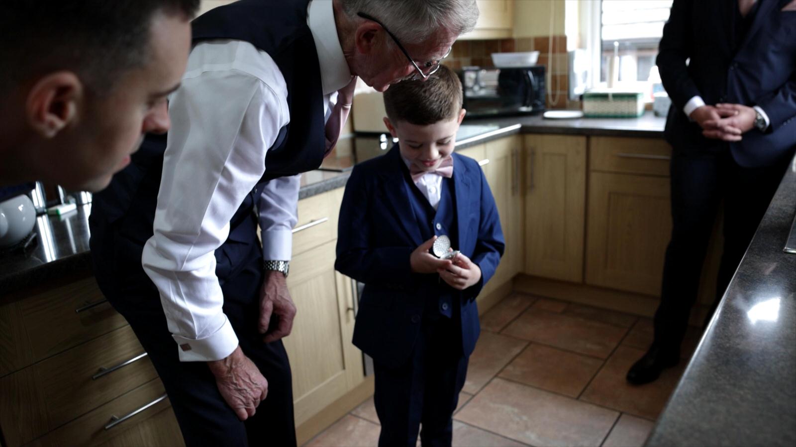 boy shows off wedding rings to grandparents