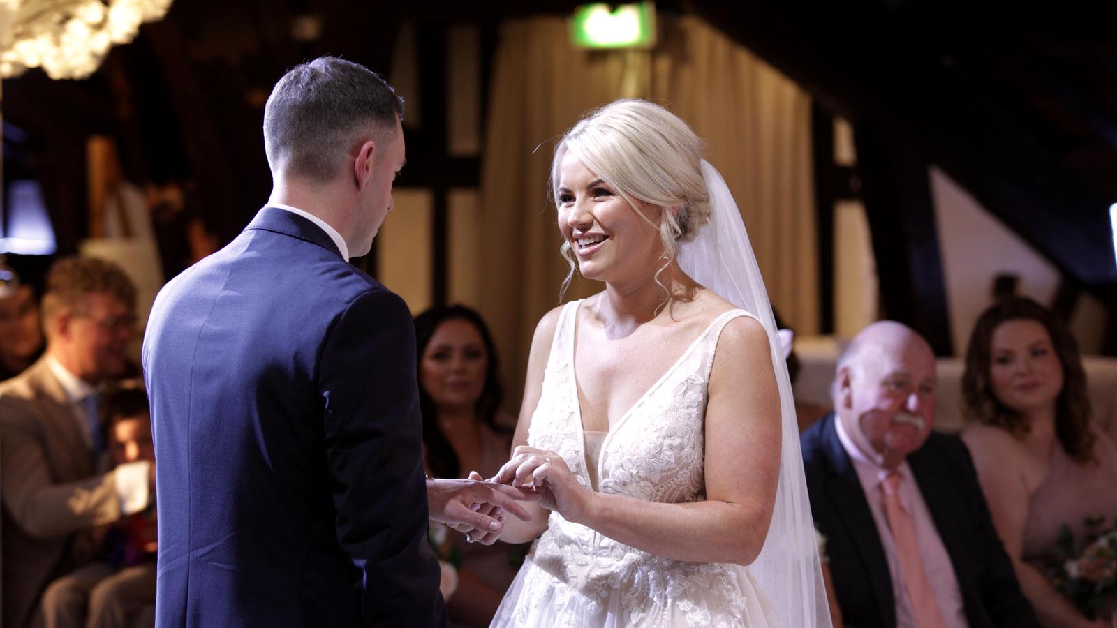 bride and groom exchange wedding rings at Rivington hall barn