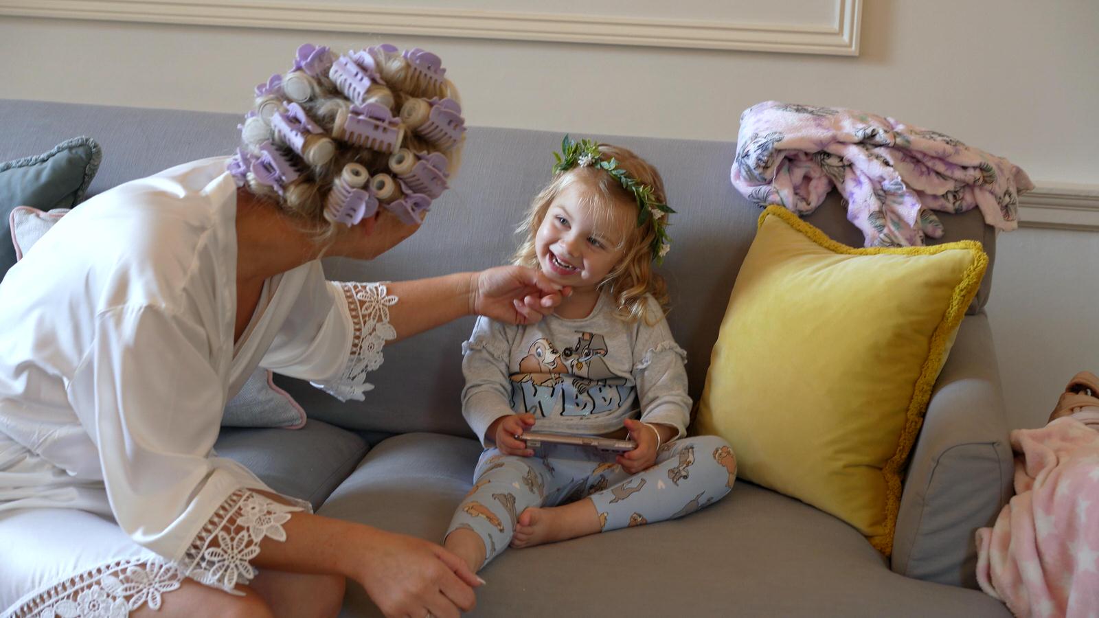 daughter flower girl smiles at her Mum on wedding video