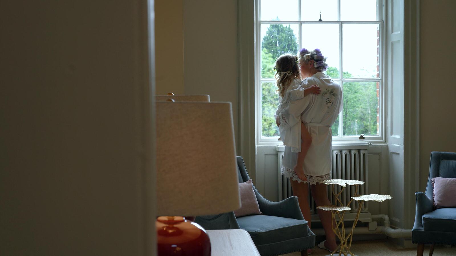 video still of mum and daughter looking out of window at Rivington hall barn