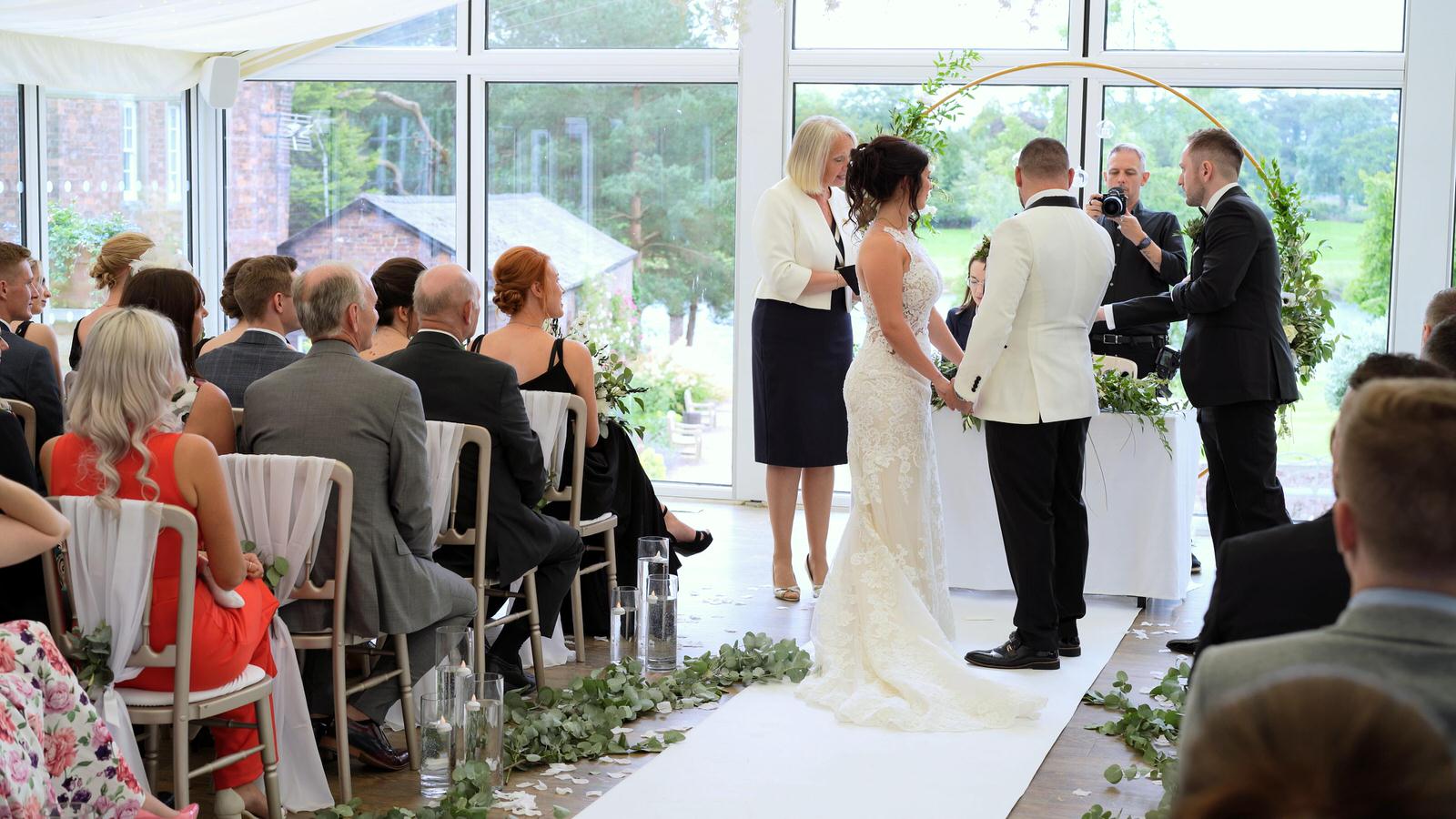 exchanging wedding rings during lakeside wing ceremony