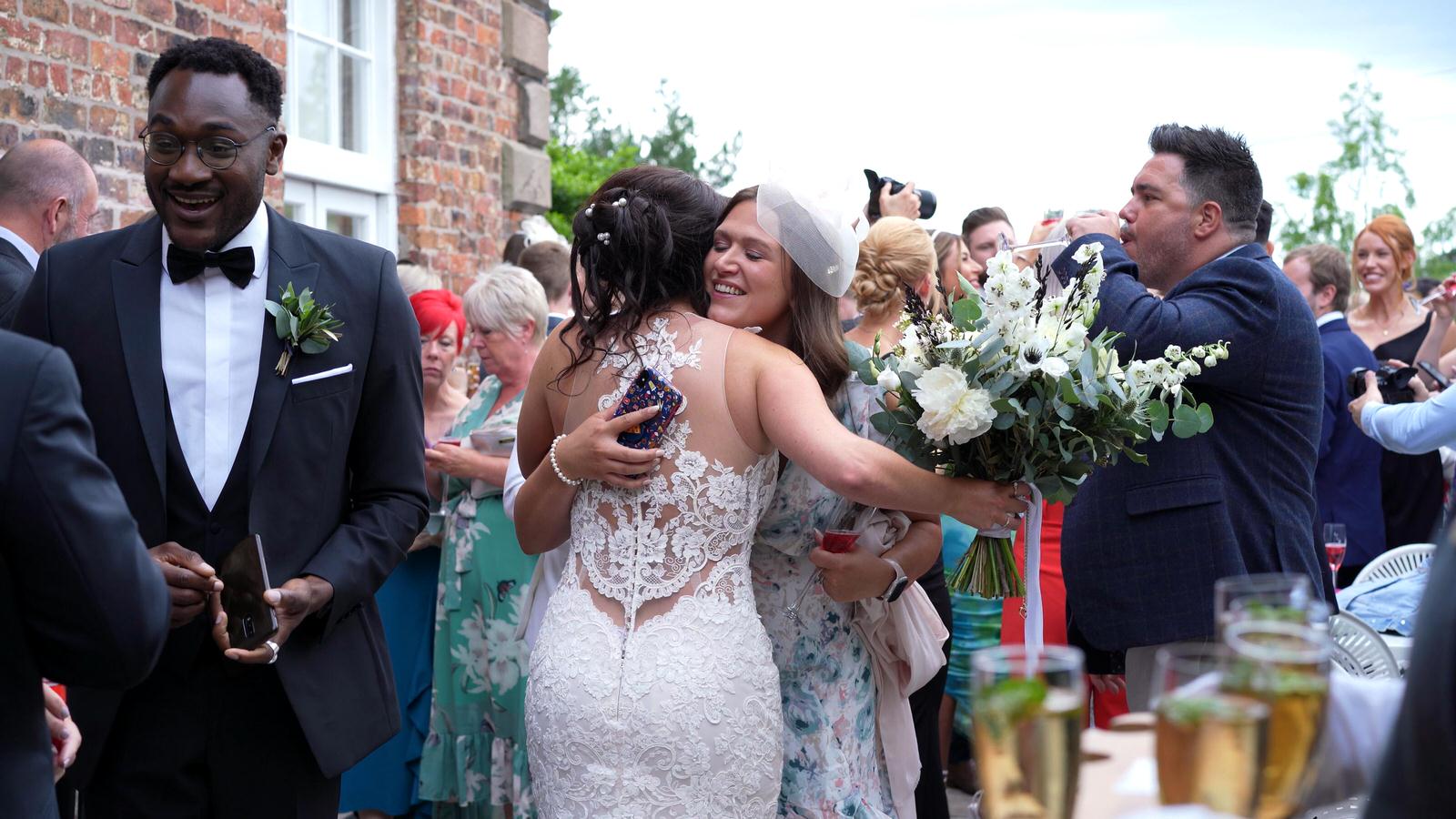 guests hug the bride on the terrace at Capesthorne Hall