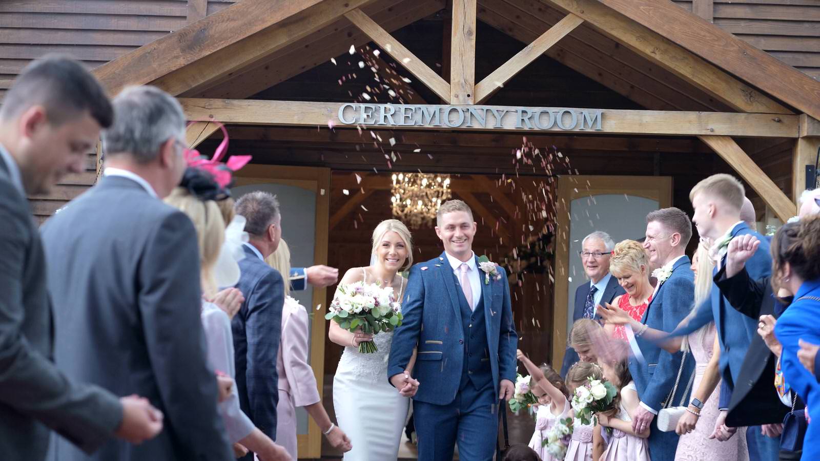 couple showered in confetti outside the ceremony room
