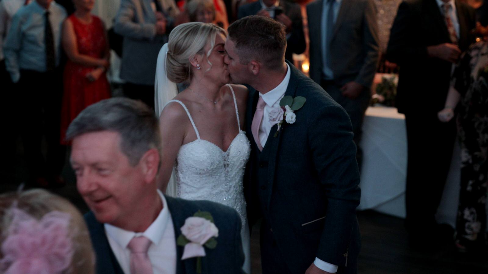couple kiss during evening reception dancing