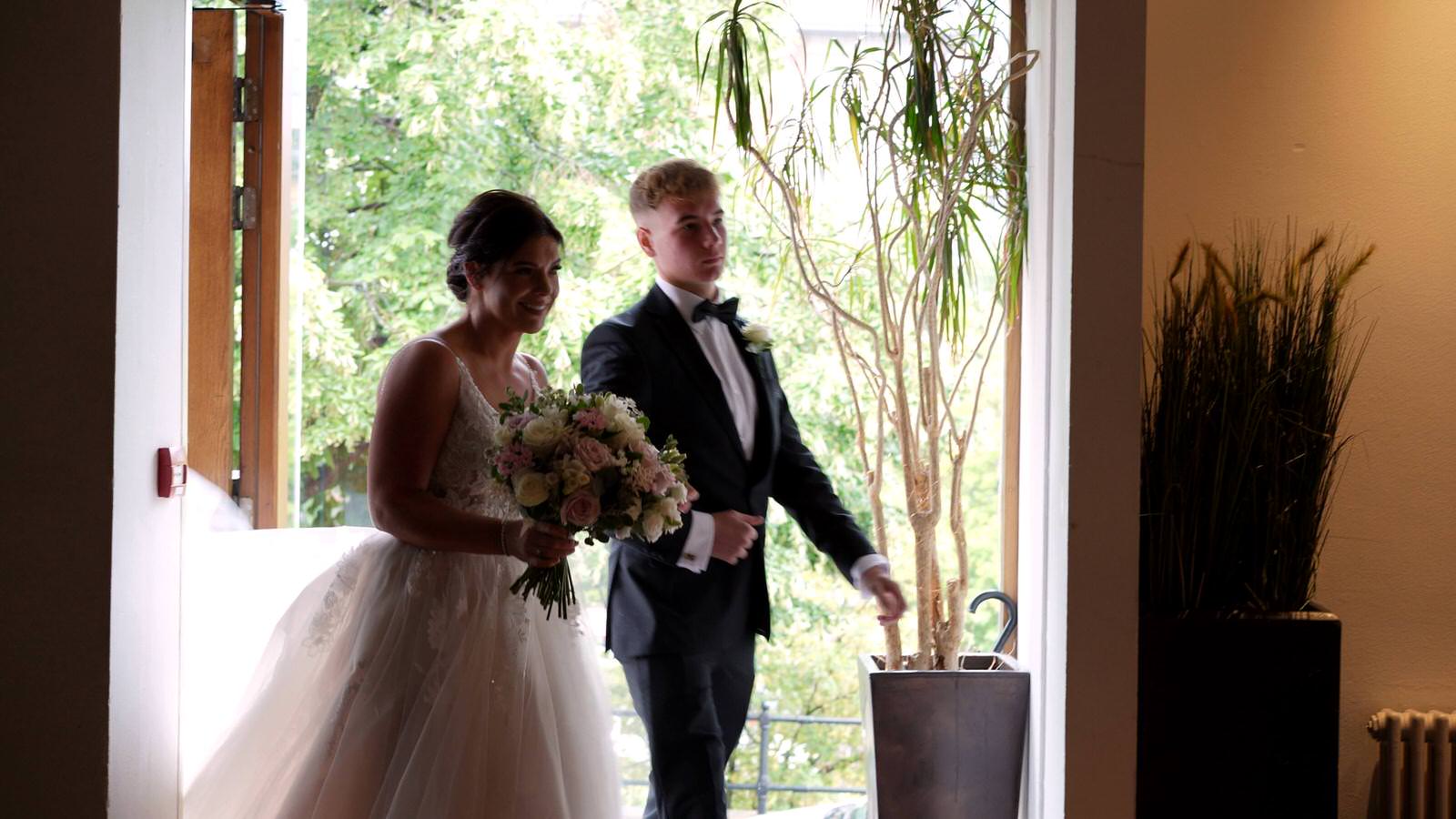 bride holds arm of her eldest son before wedding ceremony