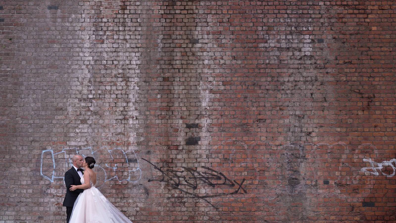 couple pose under arches near Deansgate Manchester