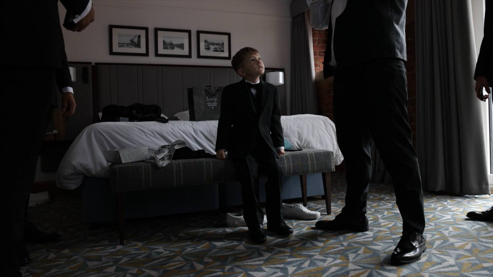 pageboy looks up at dad on wedding morning