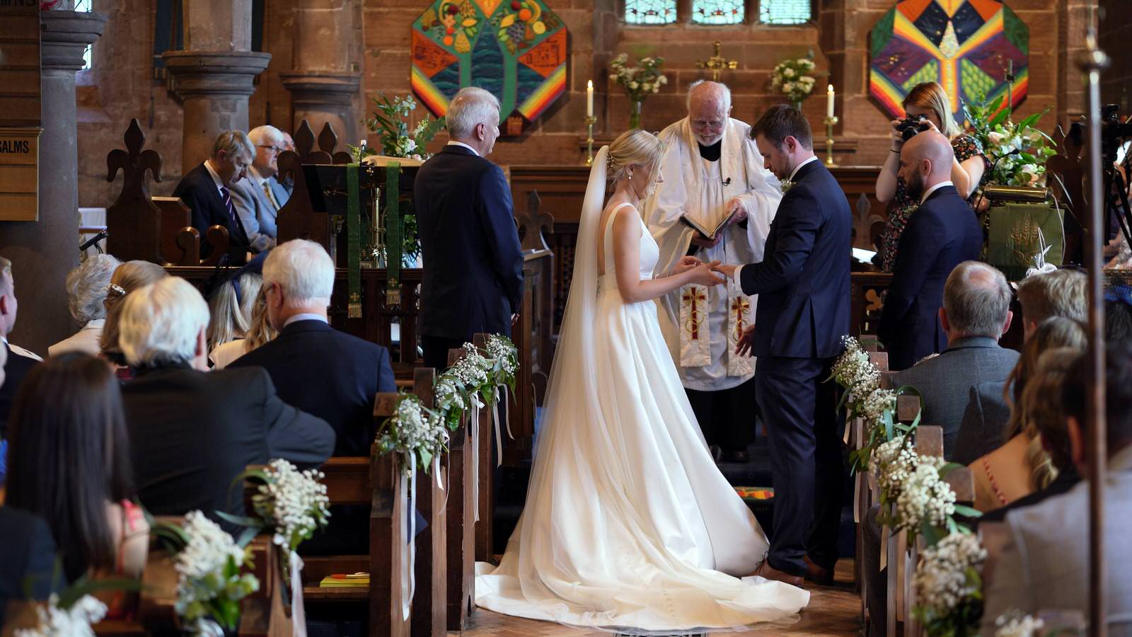 couple exchange wedding rings during village church ceremony