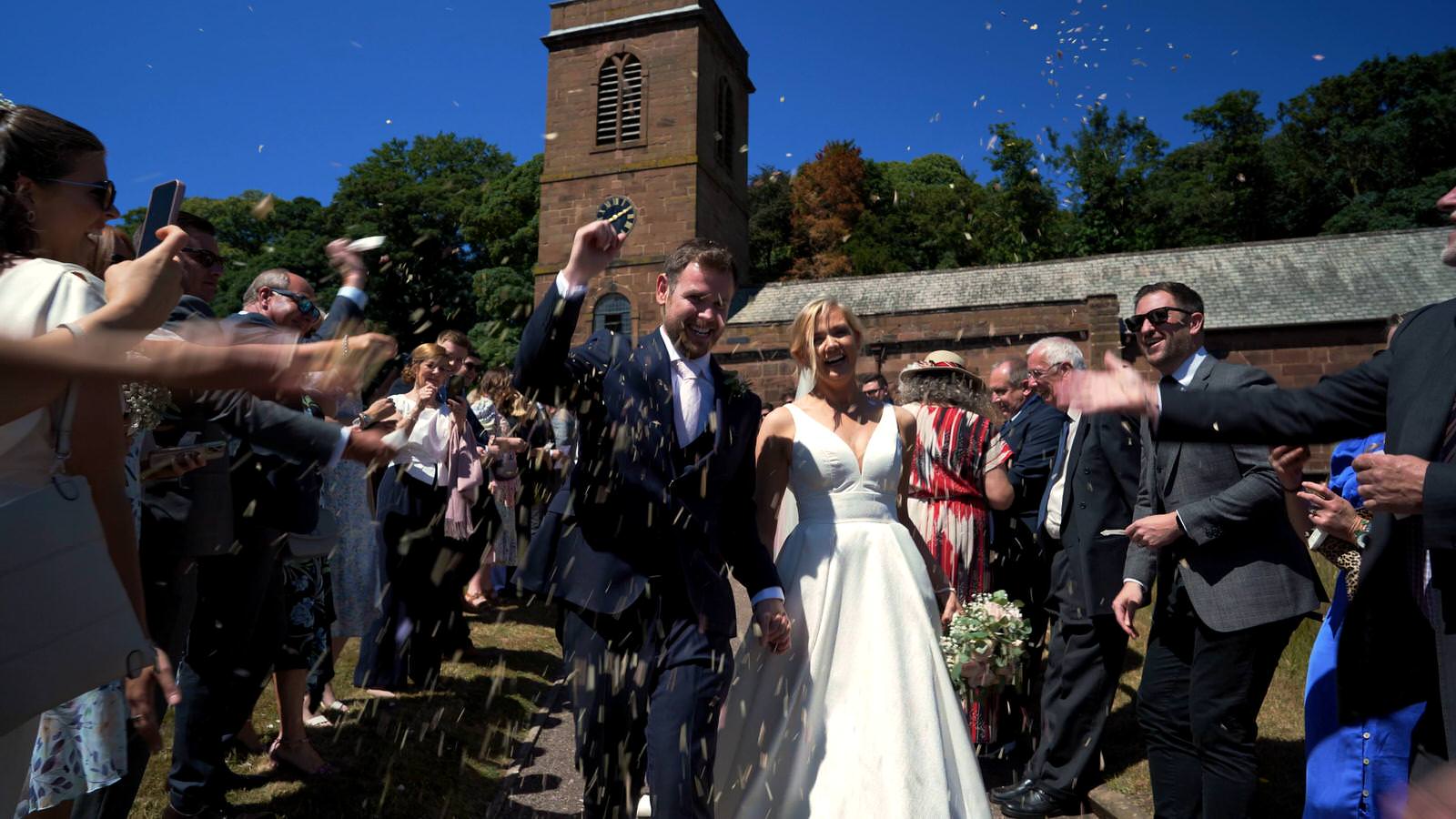 couple showered in confetti outside Burton village church