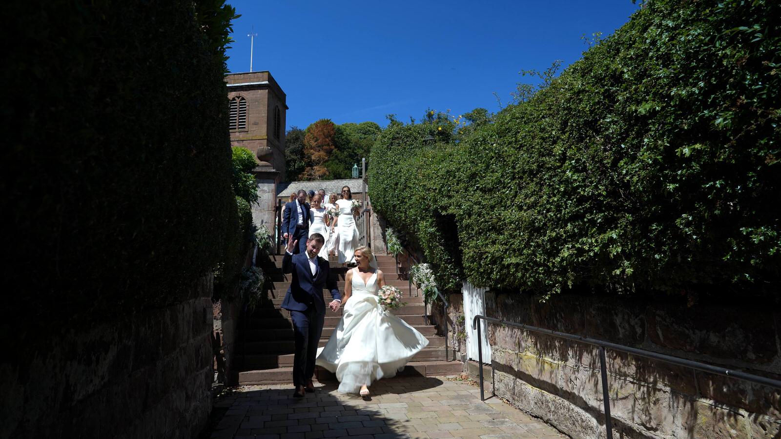couple walk from Burton Church to village hall