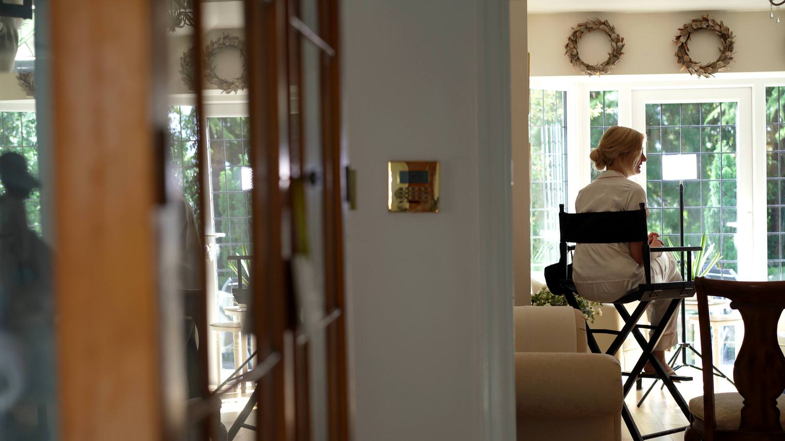 bride sits waiting in makeup chair