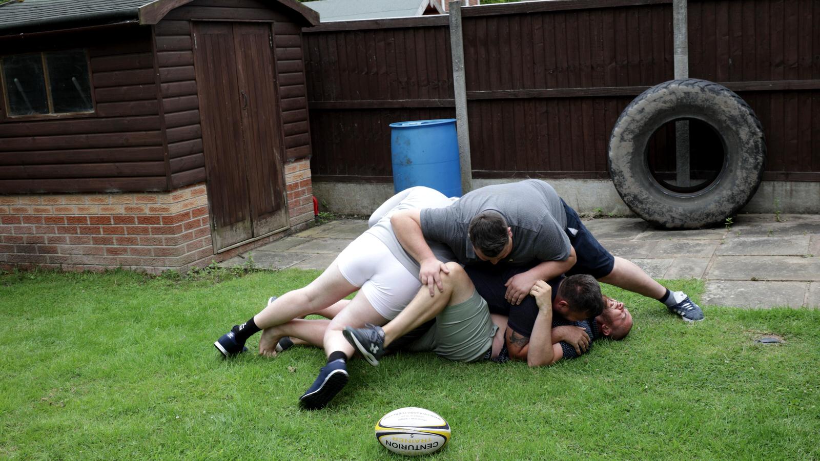 groom piles on mates playing rugby in garden