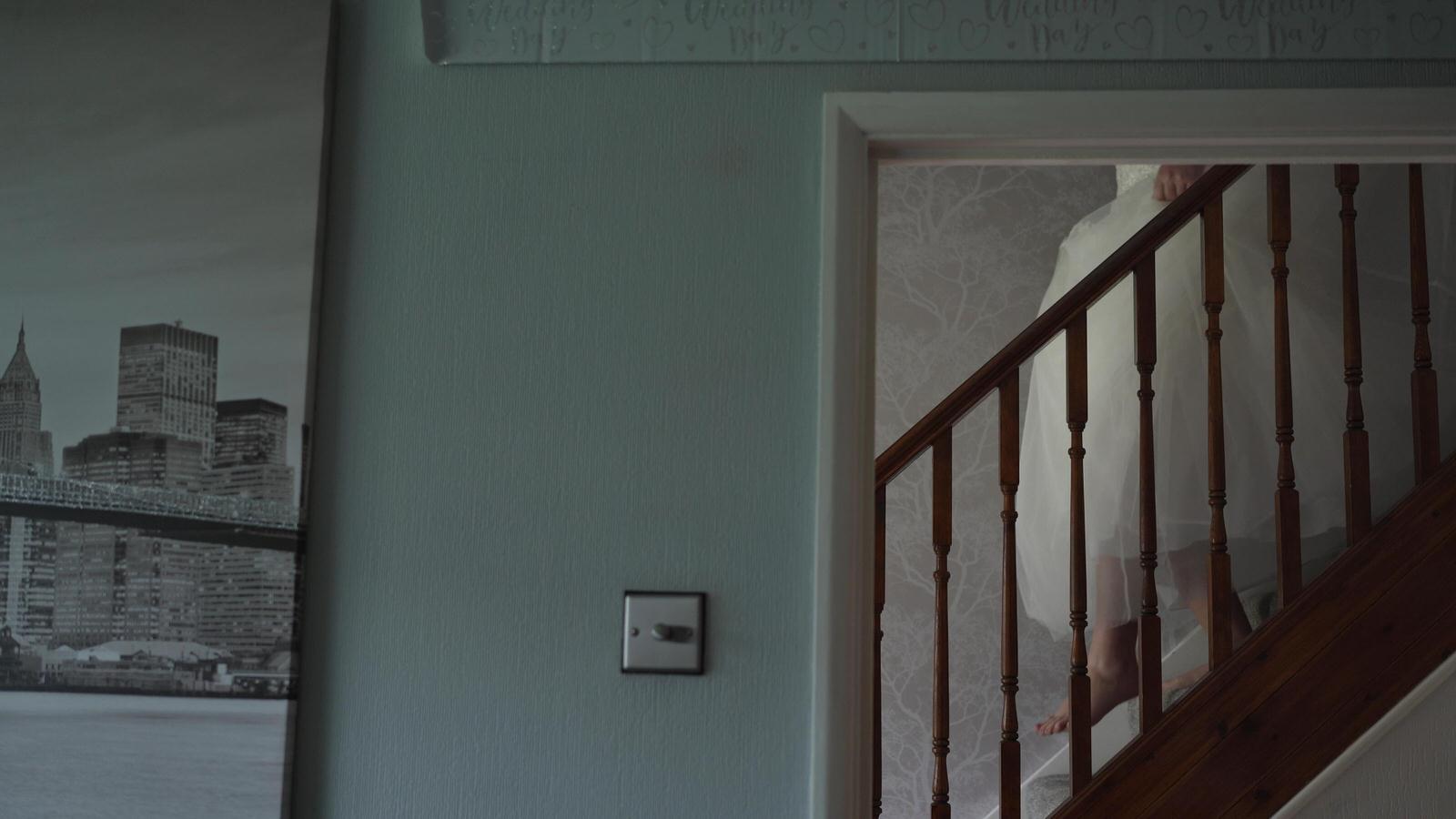 video still of bride walking down the stairs on wedding morning