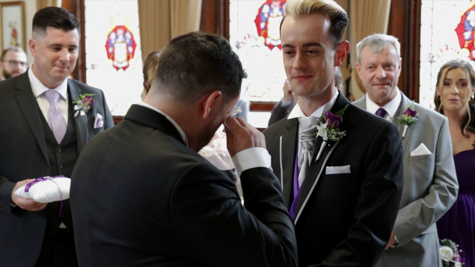 groom wipes away tears during ceremony