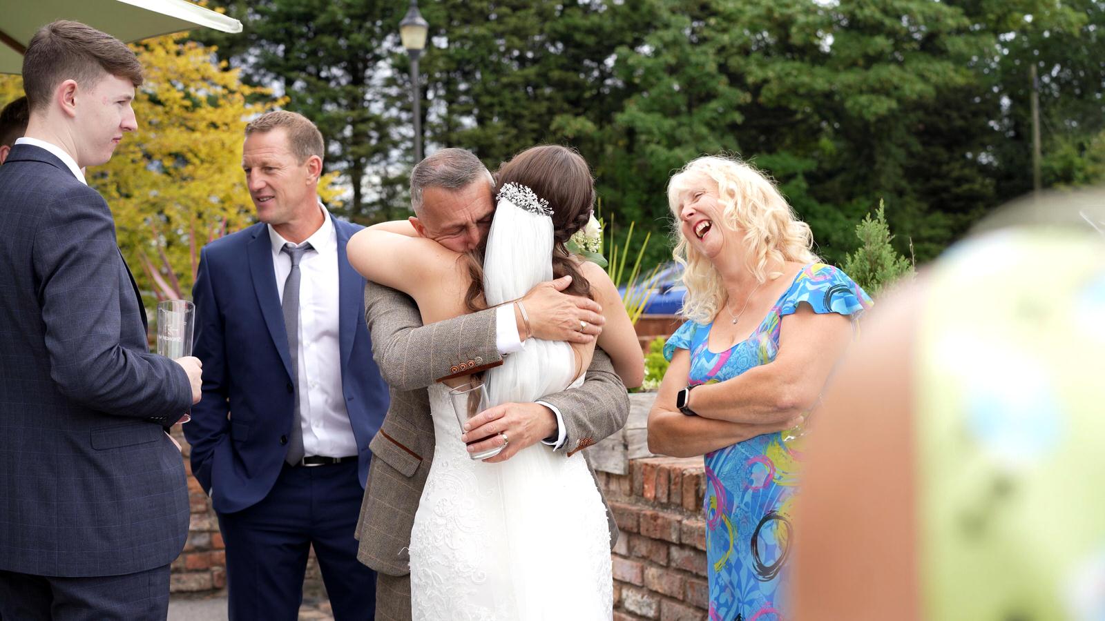 dad hugs his daughter during drinks reception at Charnock Farm