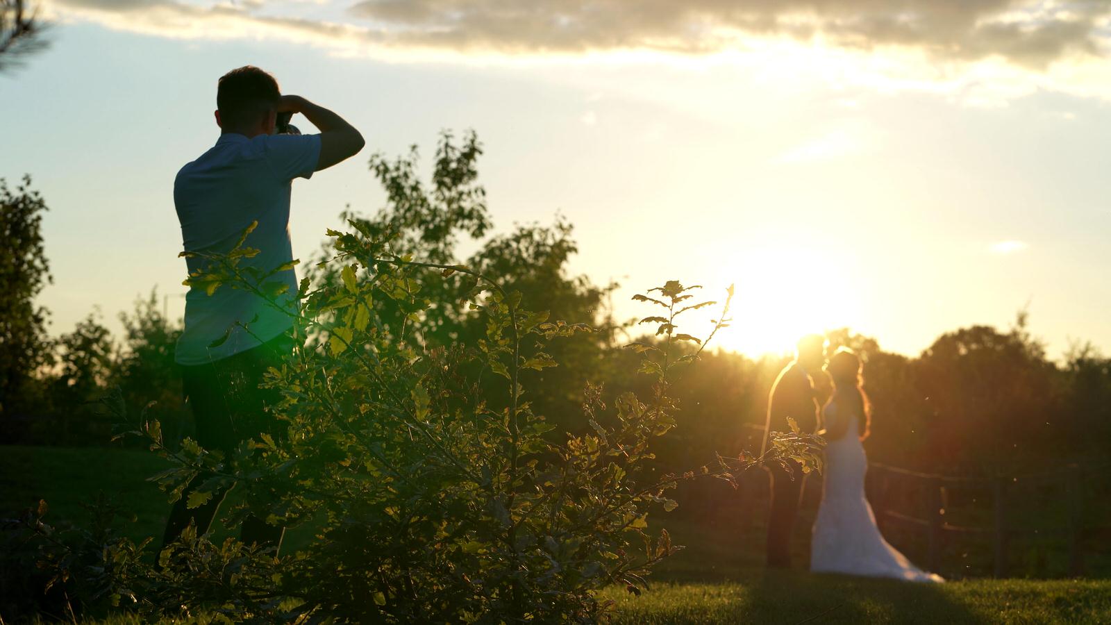 videographer filming the photographer getting a golden hour photo