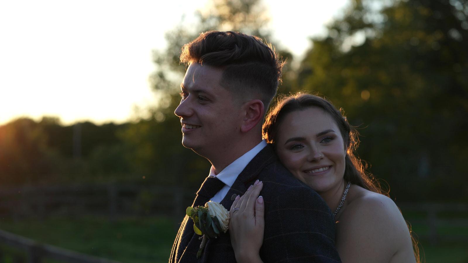 couple cuddle together outside Charnock Farm