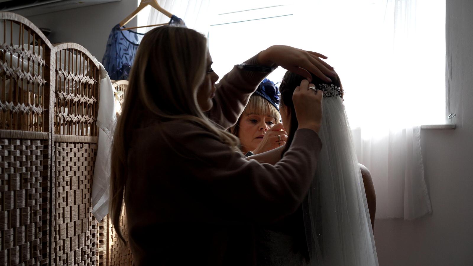a natural video shot of the bride having her veil added at Charnock Farm