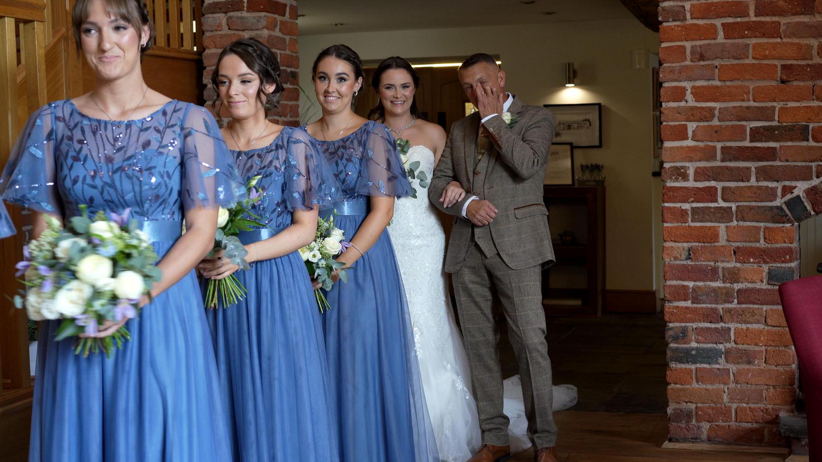 the father of the bride wipes away a tear before the charnock farm ceremony