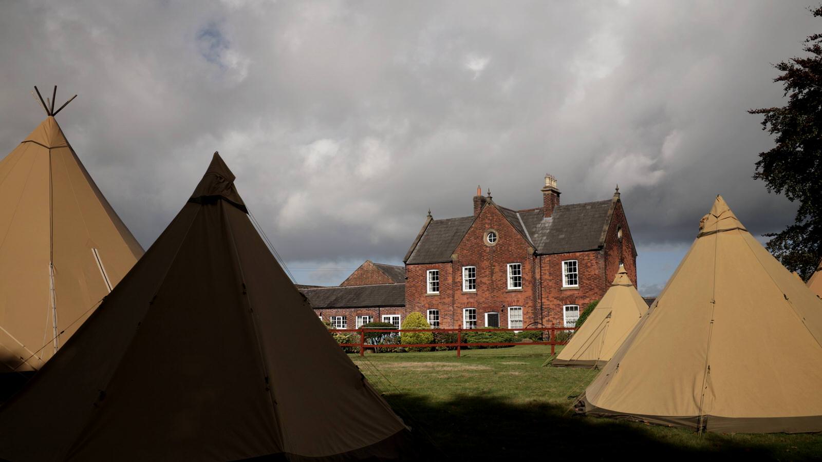 clock house farm house and wedding tipis in the sun