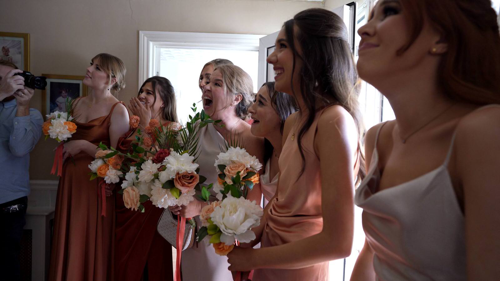mum and bridesmaids react to bride in her dress