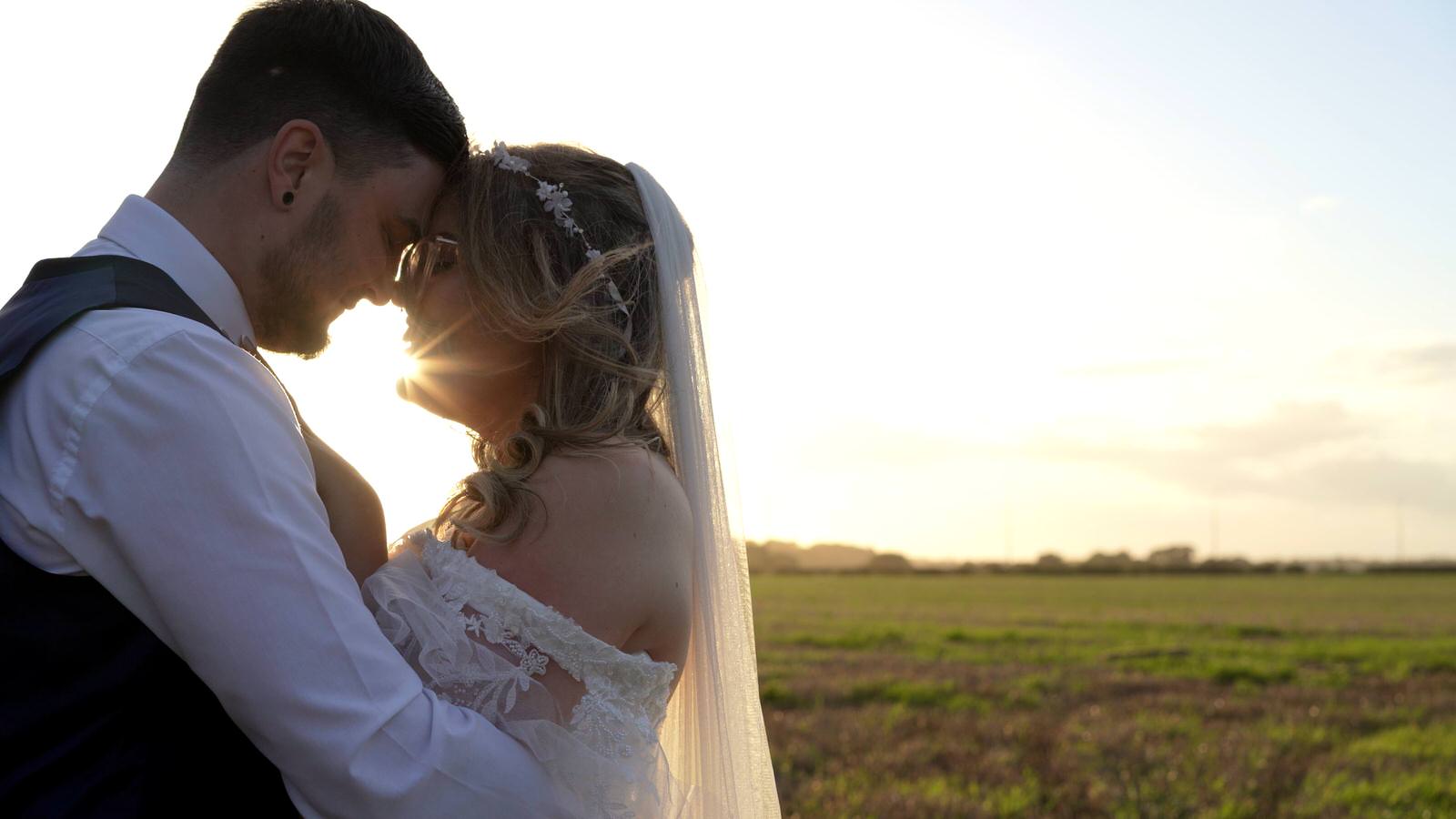 natural light video still of newlywed couple in field