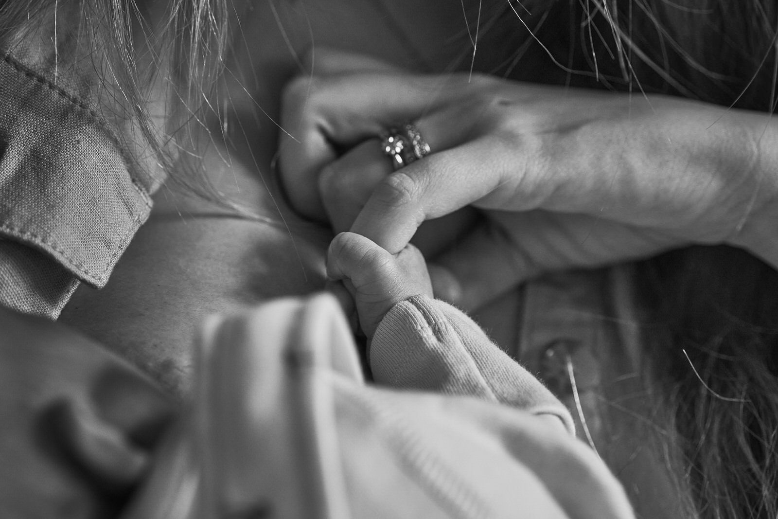 close up photo of newborn baby holding Mums finger