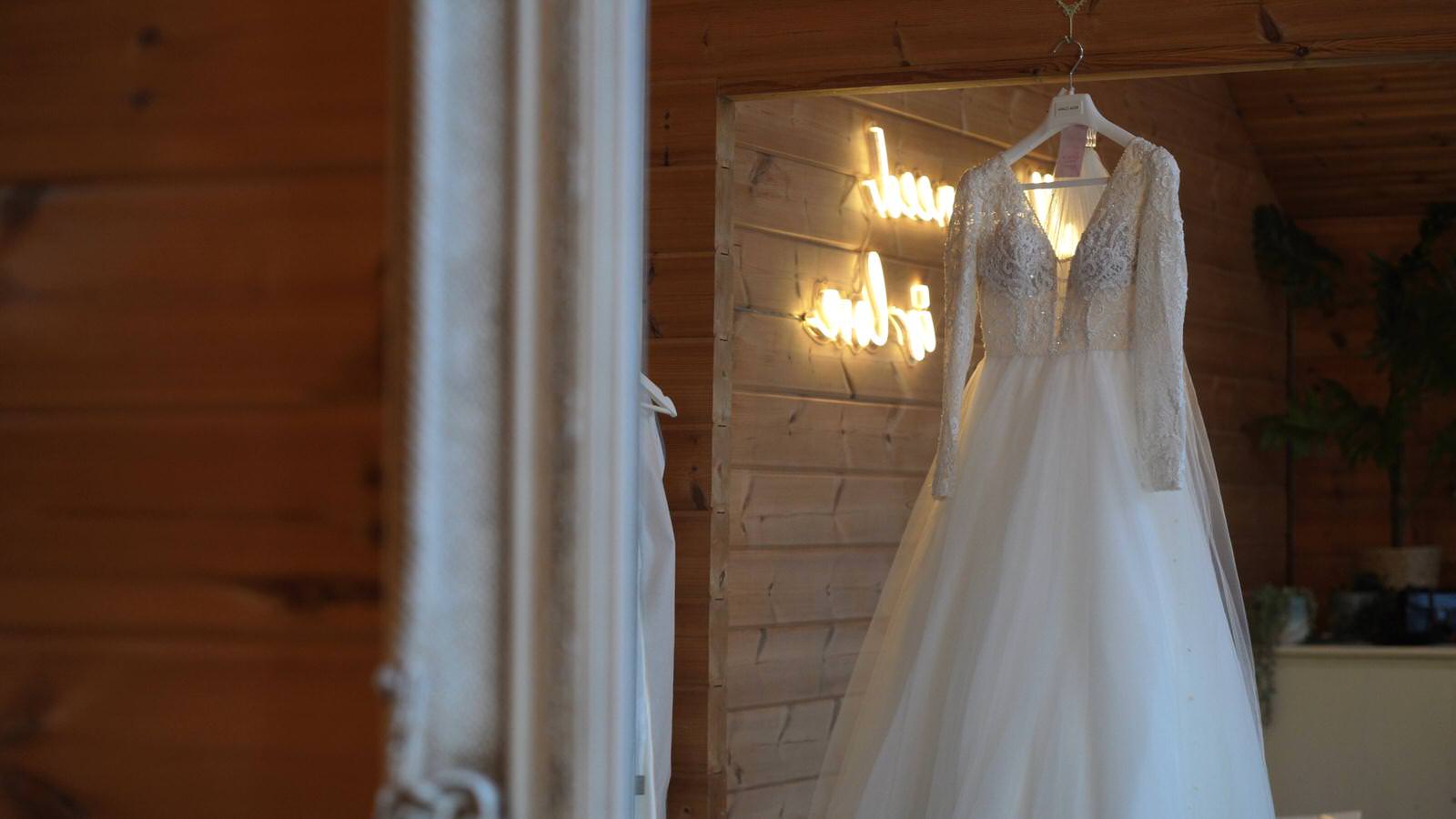lace wedding dress hangs in Styal Lodge Bridal room
