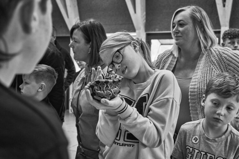 a girl looks curiously at a snake at reptile meet at Brockholes Preston