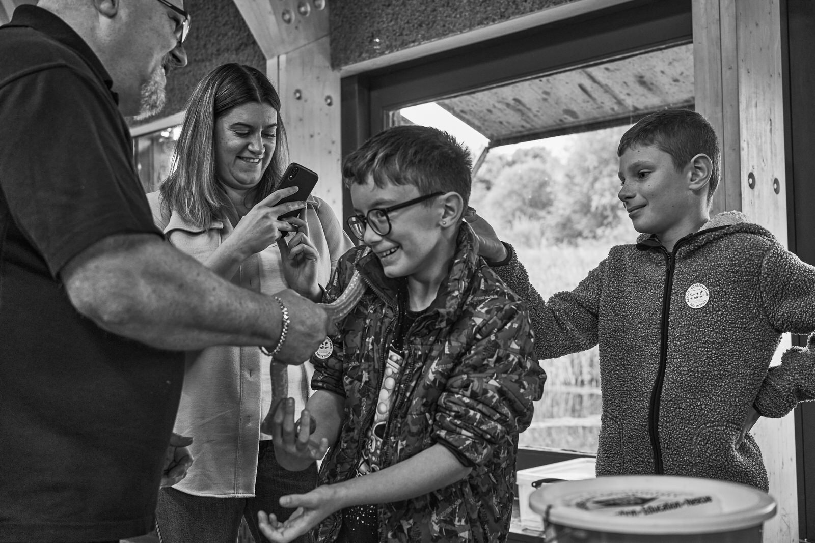 a candid photo of a nervous boy holding a snake for the first time